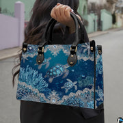 Front view of sea turtle handbag showcasing swimming turtles and ornate silver filigree lace corners.