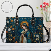 Madonna mosaic sacred art handbag staged on a white wooden table beside a decorative vase of flowers