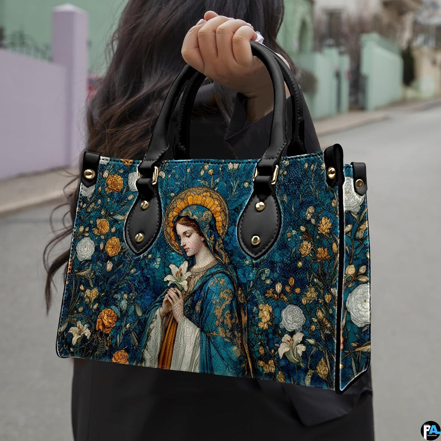 Madonna mosaic sacred art handbag held outdoors against an urban pavement and street background