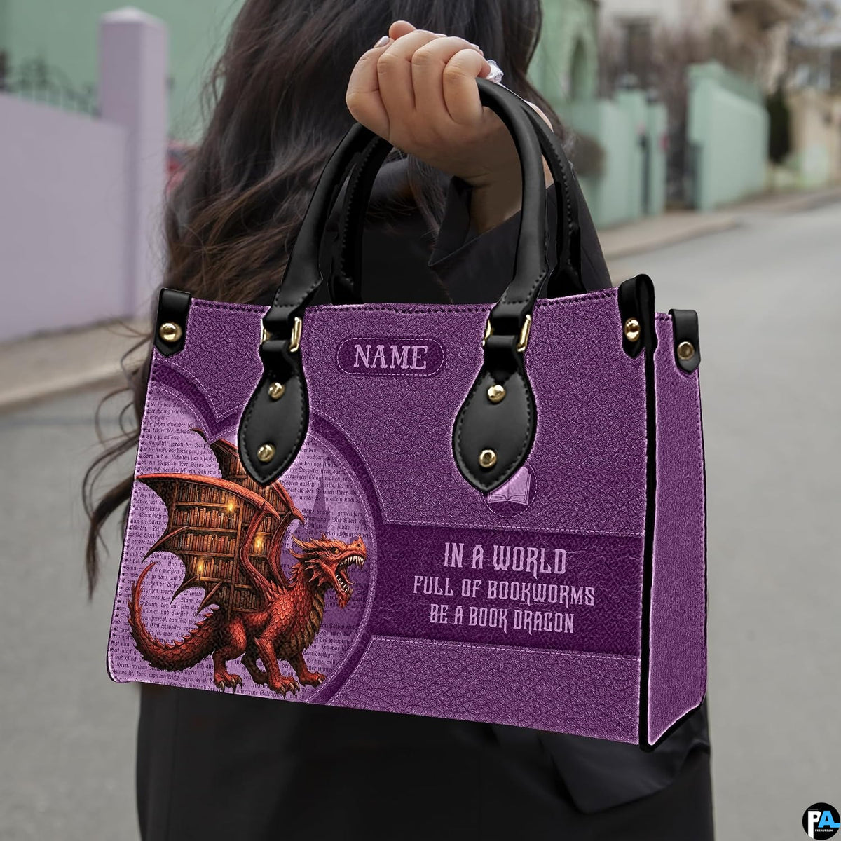 Book dragon violet handbag carried outdoors by top handle along residential street.