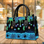 Neon eyeball handbag carried outdoors by top handle on residential street.