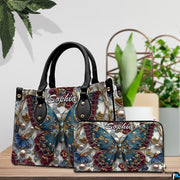 Close-up front view of handbag showing teal butterfly and gold filigree