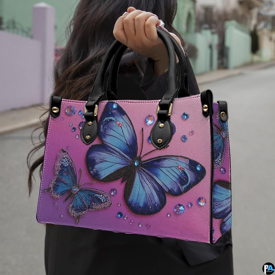 Side profile of blue butterfly handbag showing structured silhouette and black carrying handles.
