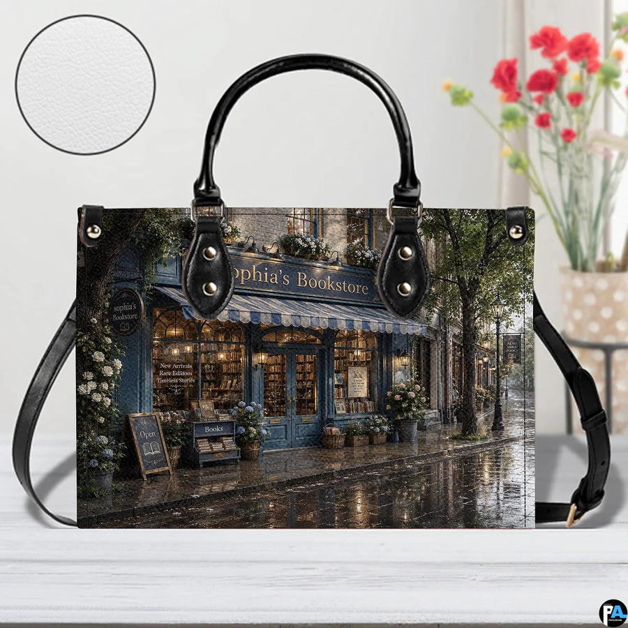Angled view displaying the reflective wet cobblestone street and shop facade across the structured handbag.