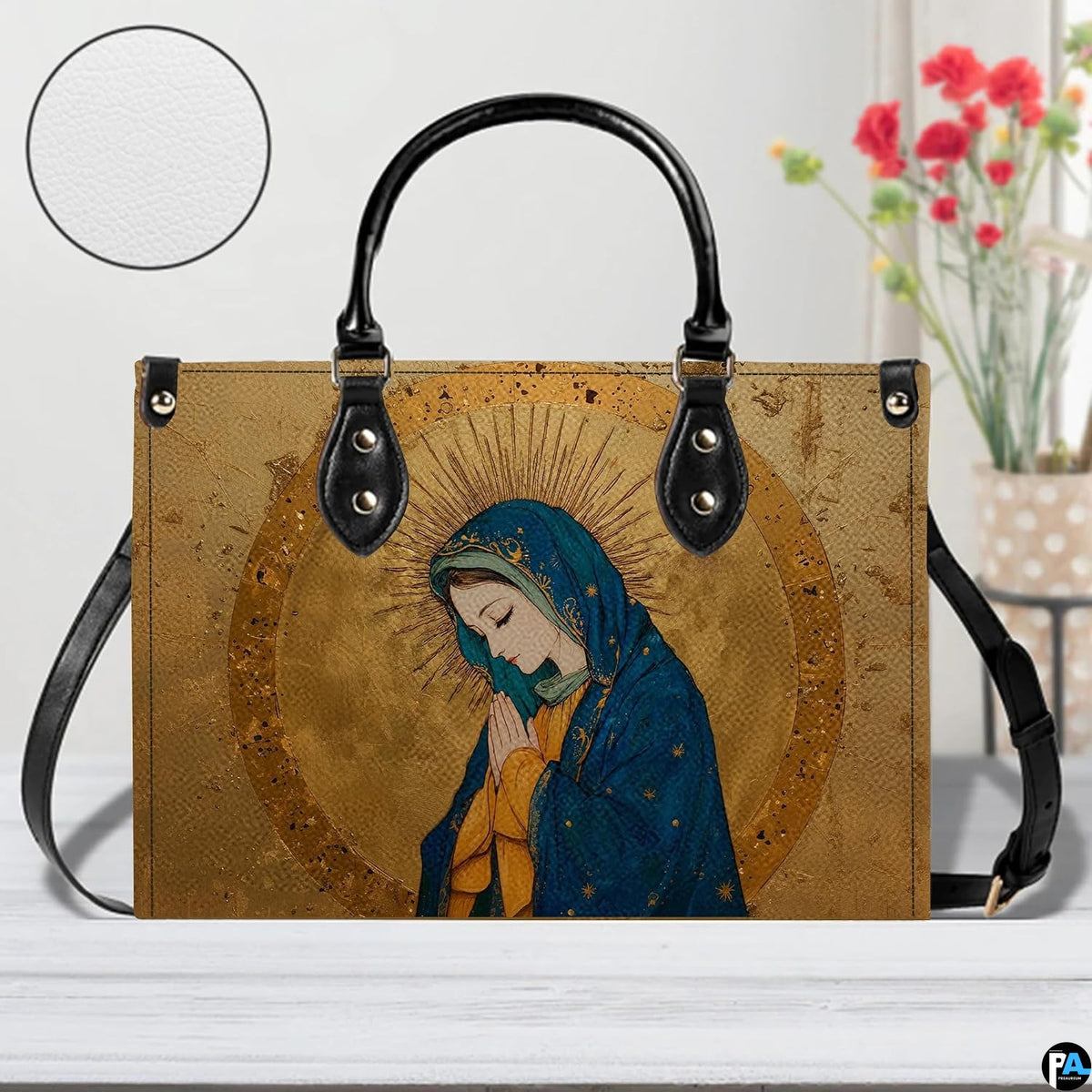 Studio staging of gilded Virgin Mary handbag with texture inset circle and floral backdrop.