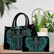 Detailed perspective of turquoise cross handbag showing handle hardware and filigree scrollwork.