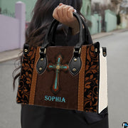 Woman carrying the western turquoise cross handbag outdoors on a residential street.