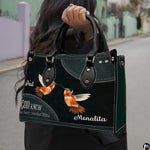 Street lifestyle view of hummingbird couple handbag held by hand on sidewalk