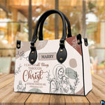 Jesus line art handbag displayed on wooden tabletop in front of sunlit cafe window.