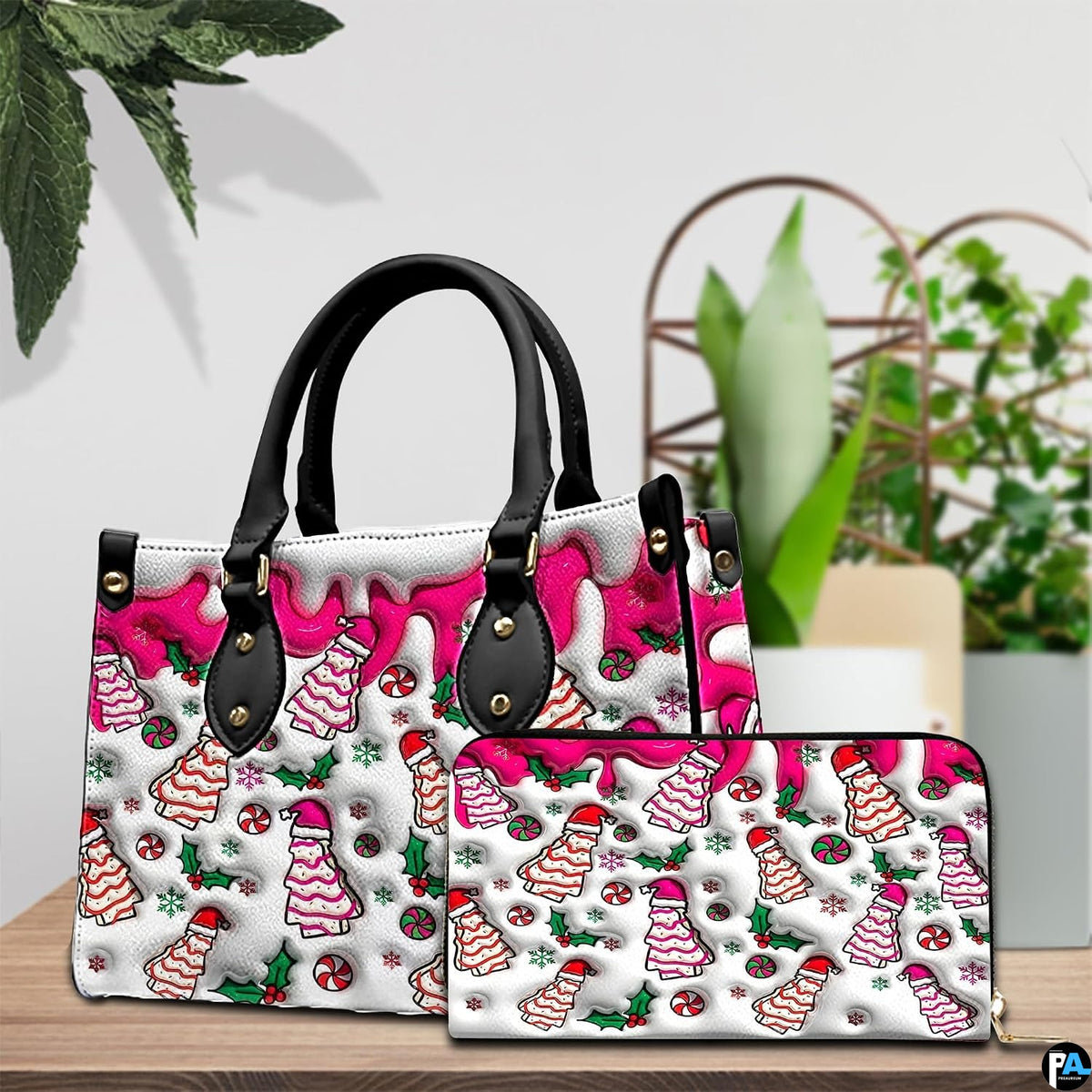 Holiday tree cake handbag and matching wallet resting on a wooden tabletop with plants.
