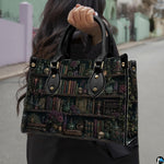 Angled view displaying the dark academia library shelf print across the structured handbag.