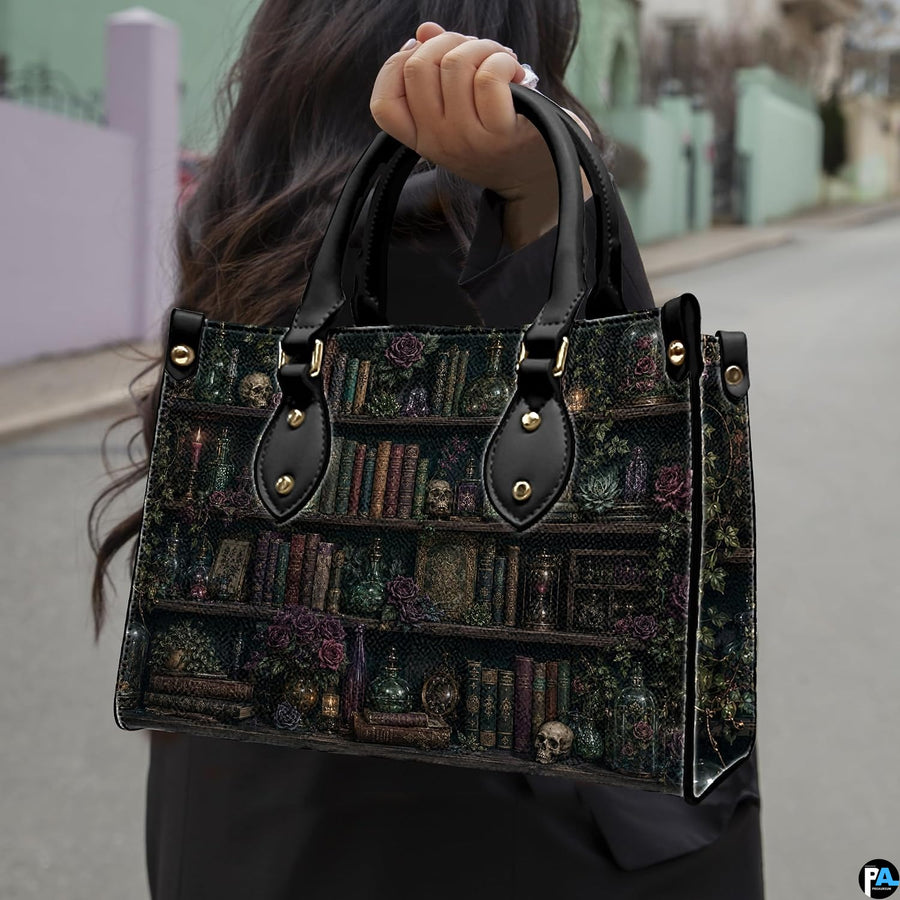 Angled view displaying the dark academia library shelf print across the structured handbag.
