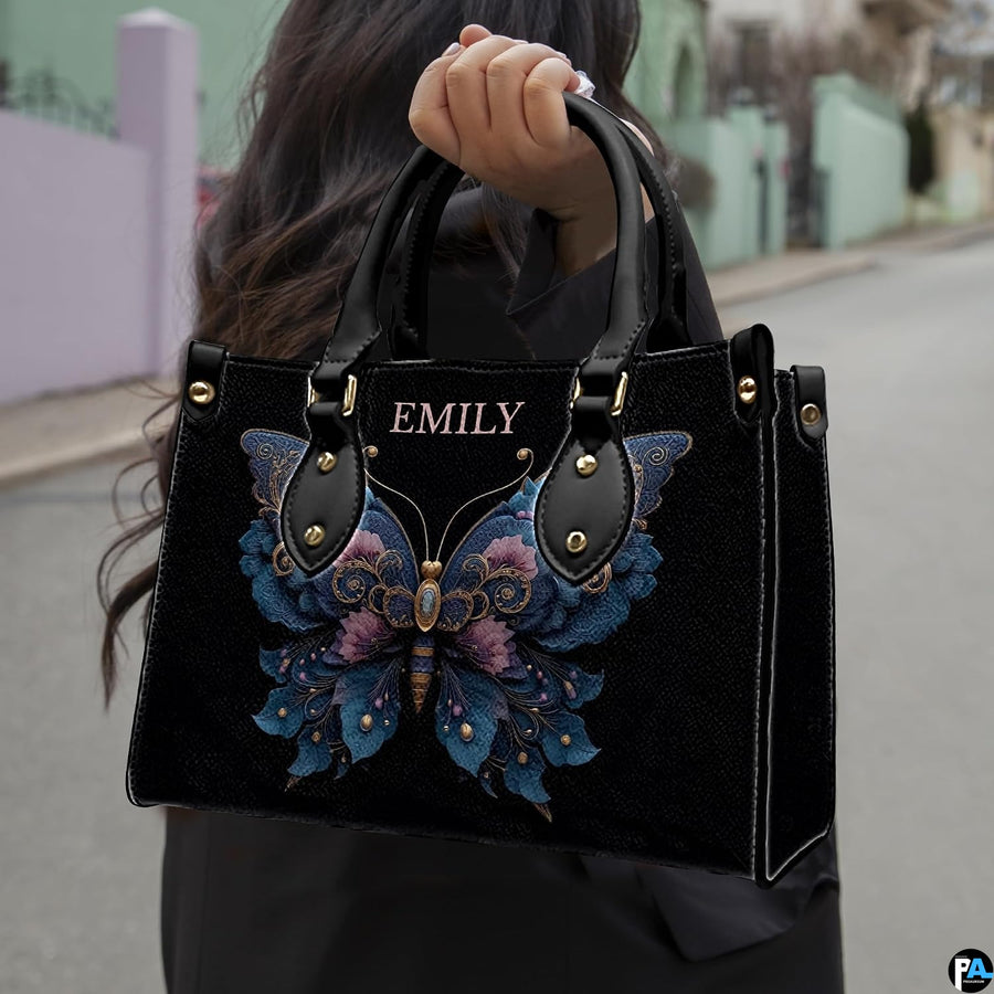 Street lifestyle view of ornate floral butterfly handbag held by hand on urban sidewalk