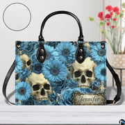 Skull floral daisy handbag on white wooden table beside floral vase with texture swatch inset.
