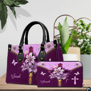 Christian cross Easter lily violet handbag and matching wallet set on wooden table near houseplant.