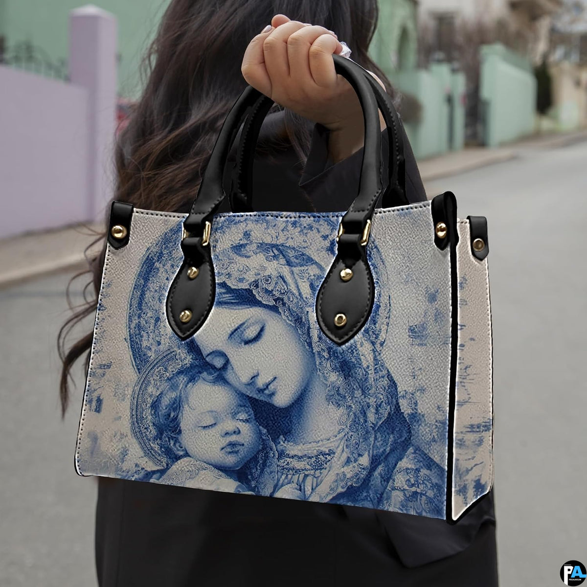 Lifestyle model carrying the blue Madonna and Child devotional handbag on street