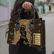 Close-up front view of woman silhouette handbag showcasing golden botanical vines and butterfly accents.