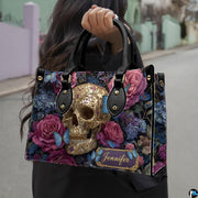 Filigree skull handbag carried outdoors by top handle along residential street.