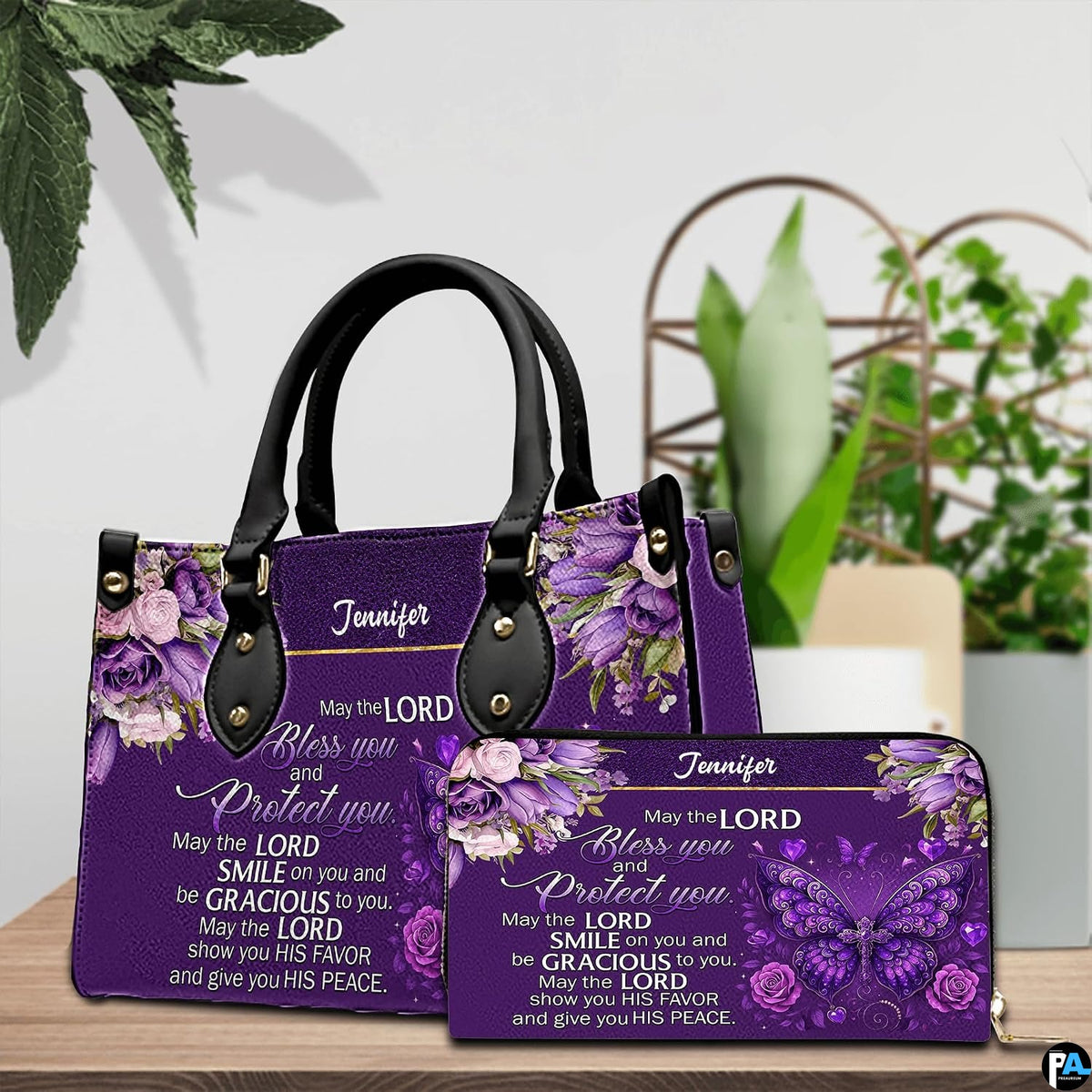 Christian blessing violet handbag and matching wallet set on wooden table near houseplant.
