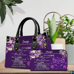 Christian blessing violet handbag and matching wallet set on wooden table near houseplant.