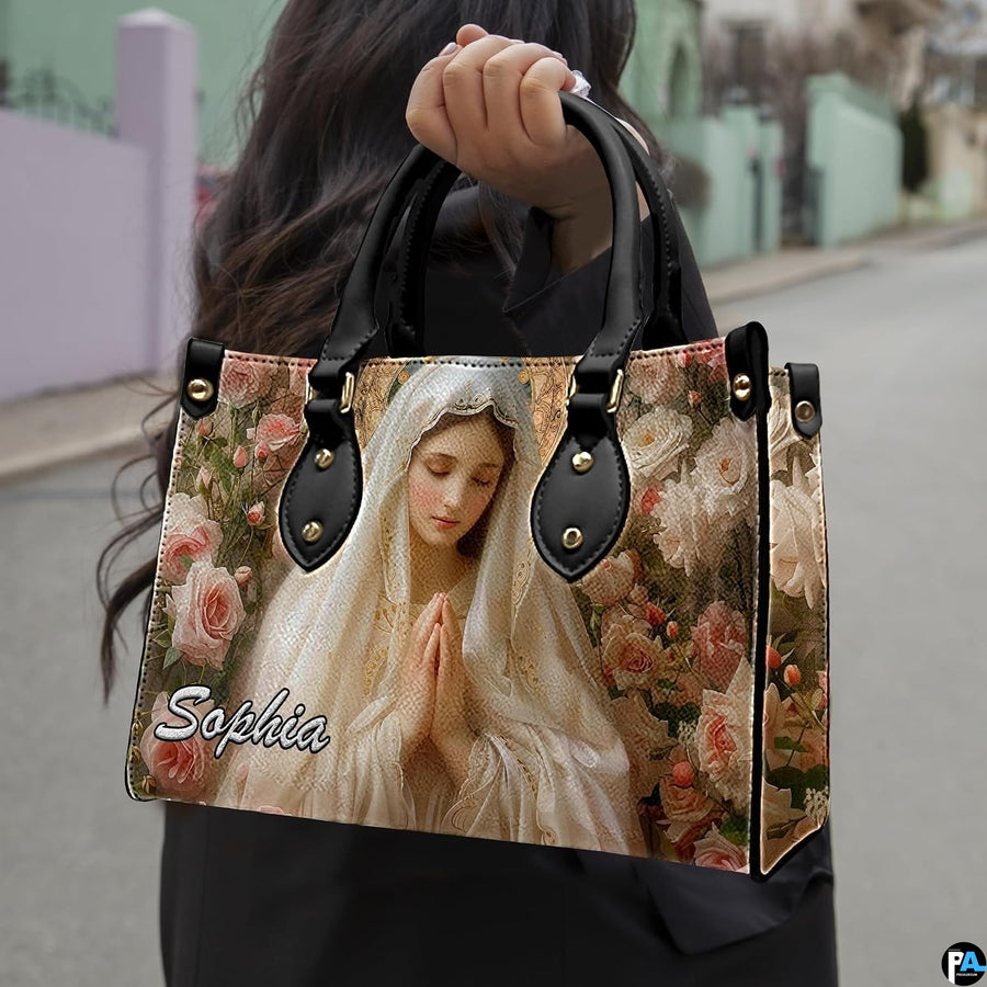 Outdoor presentation of the Virgin Mary ivory veil and rose art handbag carried by model