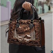 Carved Santa sleigh handbag carried outdoors by top handle along residential street.
