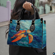 Front angled view showing the bright orange mosaic turtle gliding across cyan wave ribbons.