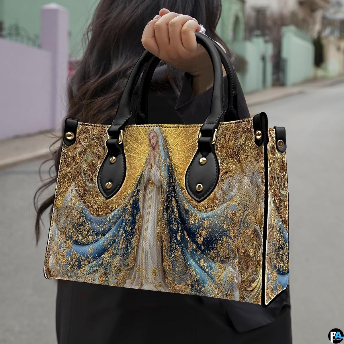 Side perspective of Virgin Mary handbag highlighting structured profile and radiant golden motifs.