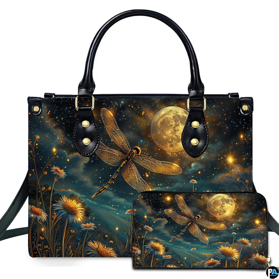 Studio display of celestial moonlit dragonfly handbag and matching wallet with glowing daisies and full moon