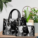 Gothic black cat handbag displayed on wooden tabletop in front of sunlit windows.