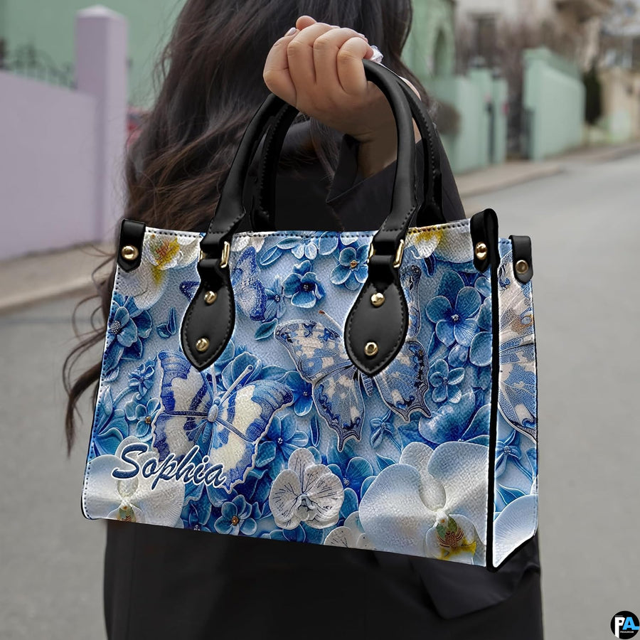 Perspective view of blue and white butterfly handbag and wallet pair