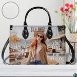Handbag displayed indoors next to flower vase with textured inset swatch.