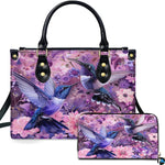 Front view of purple dual hummingbird handbag and matching wallet with blooming pink and violet flowers.