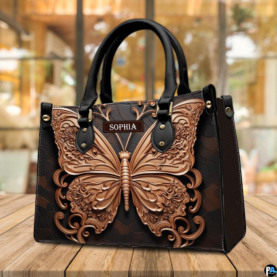 Baroque filigree butterfly handbag resting on an outdoor cafe table beside a beverage.