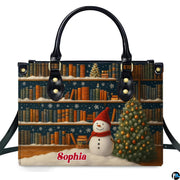 Front view of holiday handbag featuring winter library bookshelves, illuminated Christmas tree, and snowman