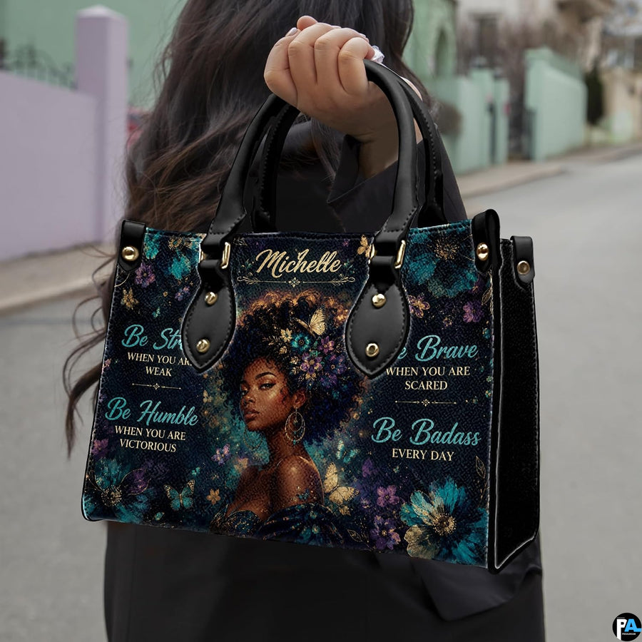 Model carrying floral afro portrait handbag with teal flowers