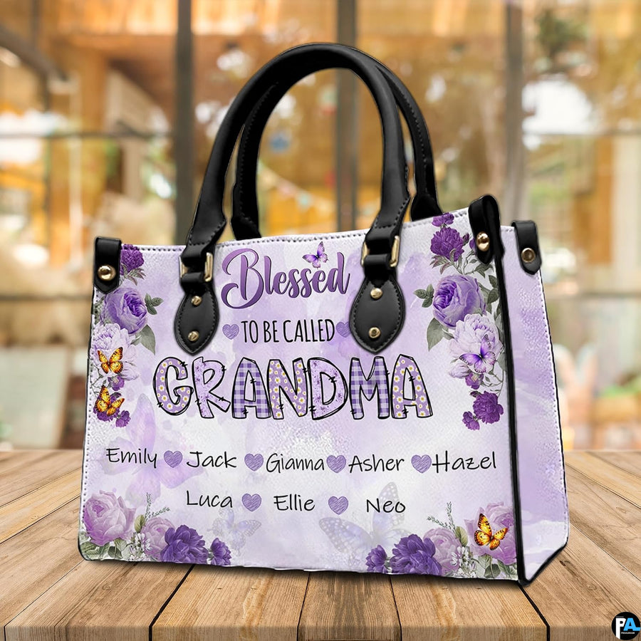 Side profile view of structured floral handbag showing sleek silhouette and black carrying handles.