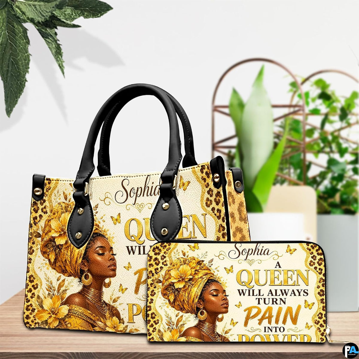 Tabletop presentation showcasing the golden empress artwork and matching accessory beside vibrant green indoor foliage.
