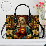 Virgin Mary floral handbag sitting on white wooden table next to fresh flower vase