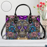Jeweled skull handbag on white wooden table beside floral vase with texture swatch inset.