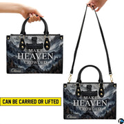 Side perspective view of mountain cross handbag and wallet showing structured profile