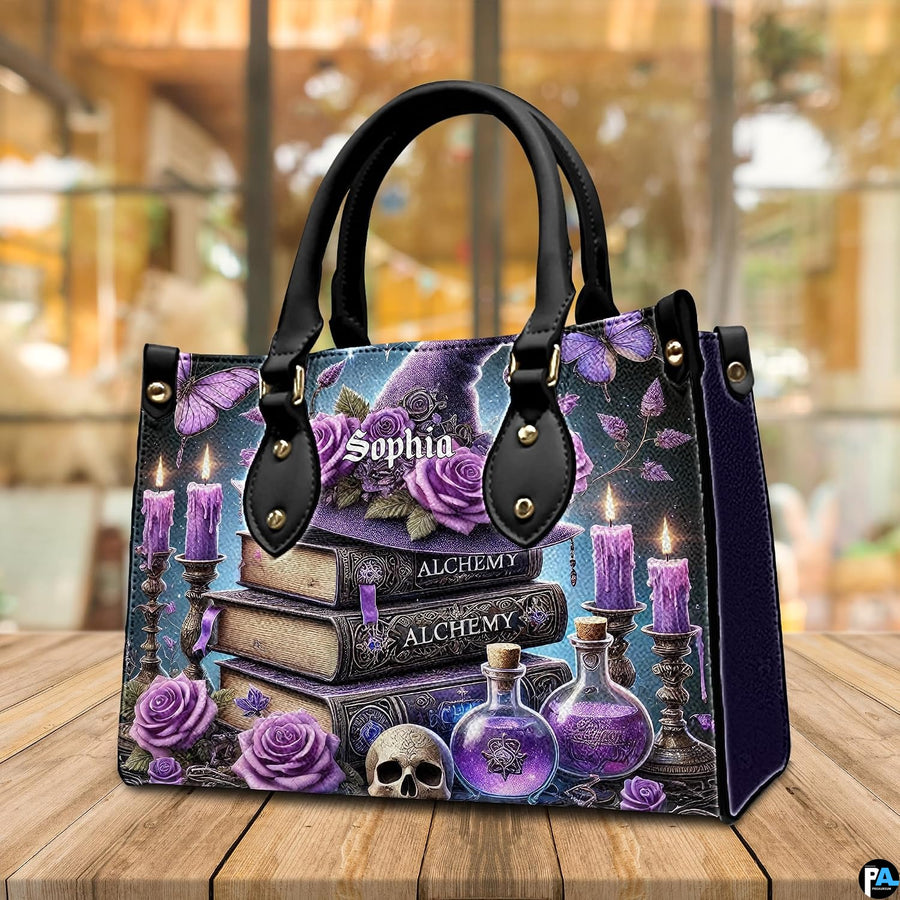 Witchcraft themed handbag resting on wooden cafe table with warm bokeh backdrop.