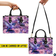 Close perspective of iridescent blue hummingbird feathers and pink dahlia petals on handbag.