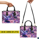 Close perspective of iridescent blue hummingbird feathers and pink dahlia petals on handbag.