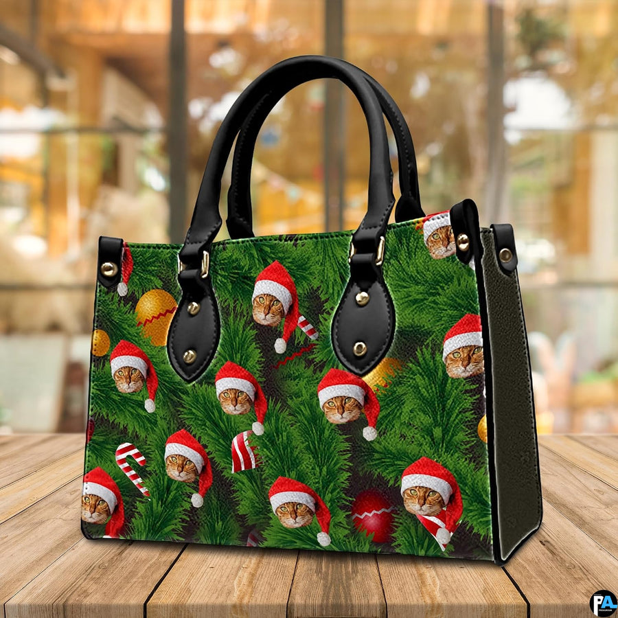 Angled tabletop perspective of holiday handbag with festive cat and evergreen pine needle print
