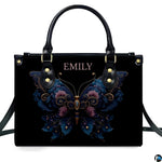 Straight-on studio portrait of black ornate floral butterfly handbag on white background