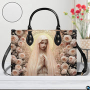 Blush rose Marian handbag shown on white wooden table with texture swatch and background floral vase.