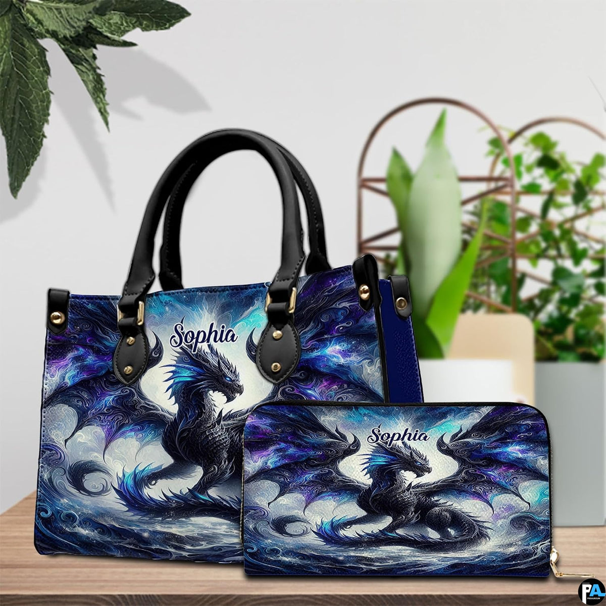 Cosmic shadow dragon handbag and wallet set shown together on wooden tabletop next to green plant.