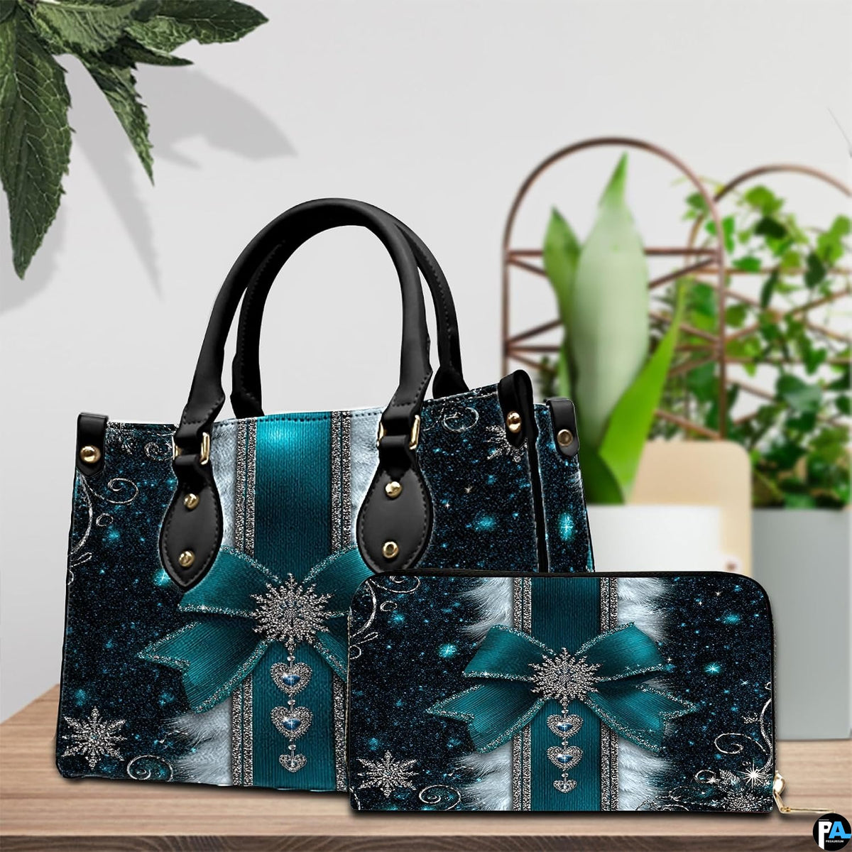Teal snowflake bow handbag and matching wallet resting on a wooden tabletop.