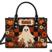 Front view of autumn satchel displaying cute smiling ghost on orange and black plaid grid with pumpkins.